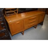 A vintage teak and laminate sideboard having stylised legs