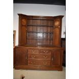 A traditional oak dresser having delft rack flanker by two corner style cupboards over drawer and