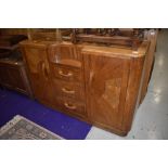 A 1930s oak and ply sideboard of interesting design having central recess over three drawers flanked