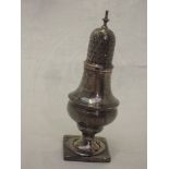 A Georgian silver caster of waisted baluster form having square pedestal foot and pierced push on