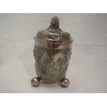 A Swiss silver lidded canister having trefoil bun feet, gilt interior and repousse floral decoration