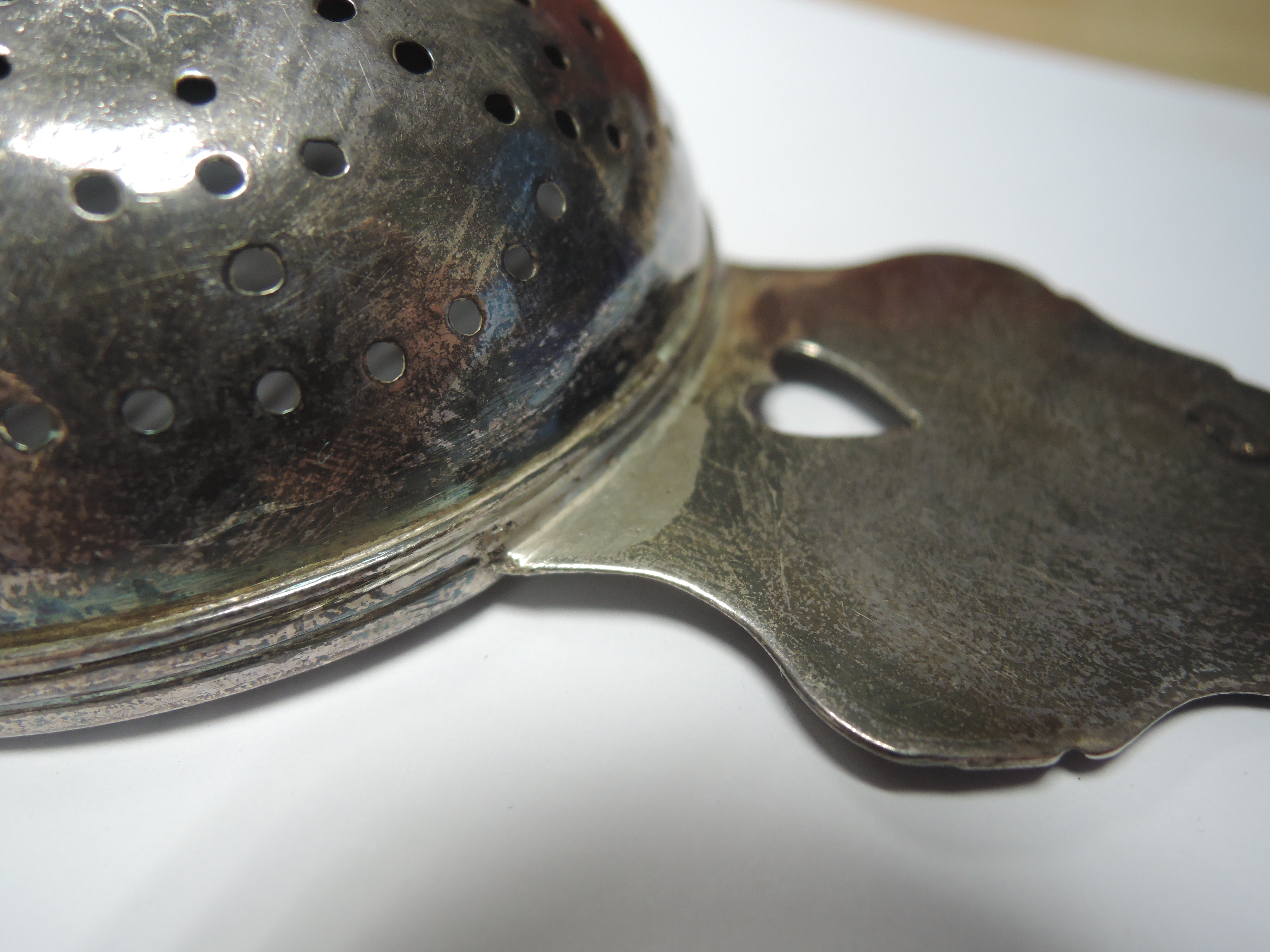 A Queen Anne Britannia silver lemon strainer having pierced bowl and heart cuts to the handles, - Image 7 of 10