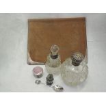 A small selection of HM silver including cut glass perfume bottles having silver collars and lids,