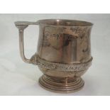 A silver christening mug bearing monogram to front and date to base with Celtic style handle and