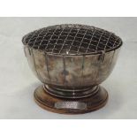 A silver rose bowl having fluted decoration, wire flower grill and a wooden presentation plinth,