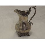 A Victorian silver jug of baluster form having engraved decoration with moulded loop handle and