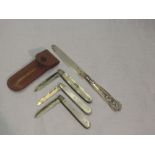 Two Edwardian folding fruit knives having HM silver blades and mother of pearl handles, a similar