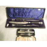 A cased three piece carving set having black antler handles with white metal finials, James