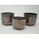 A pair of Victorian silver beakers having weighted bases, hammered decoration and bearing wedding