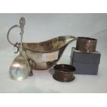 An Edwardian silver sauce boat of plain form having trefoil paw feet, loop handle and reeded rim,