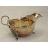 A silver sauce boat having trefoil pad feet, loop handle and shaped rim, Birmingham 1948, Adie