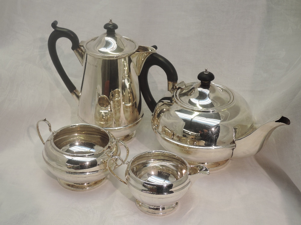 A four piece silver tea set of plain compressed circular and baluster form having banded waist,