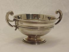 An Edwardian silver trophy bowl of small form having moulded loop handles, London 1903, Charles &