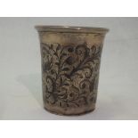 A Russian silver beaker having niello foliate scrolling decoration, flared rim and gilt interior,