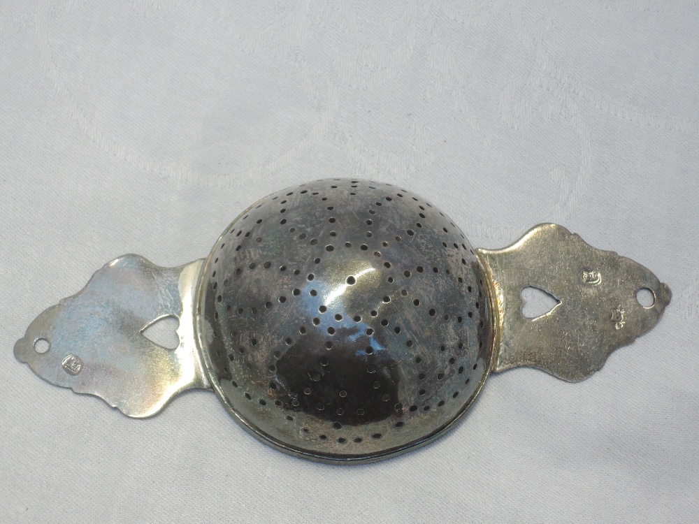 A Queen Anne Britannia silver lemon strainer having pierced bowl and heart cuts to the handles, - Image 2 of 10