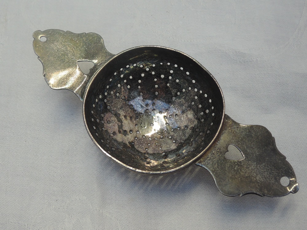A Queen Anne Britannia silver lemon strainer having pierced bowl and heart cuts to the handles,