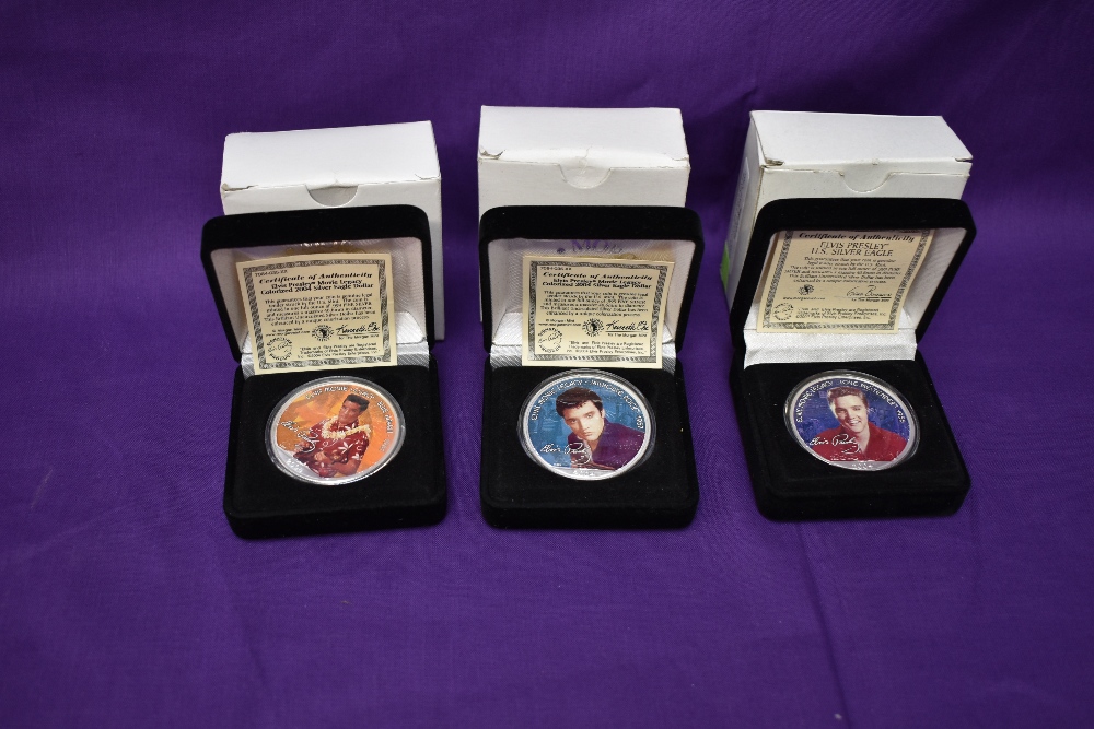 Three Morgan Mint Elvis Presley 2004 Silver Dollars in cases, each coloured on one side, each named,