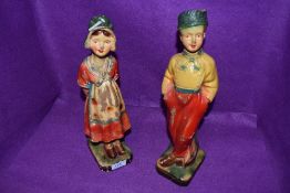 A pair of art deco chalk ware figurines of a boy and a girl.