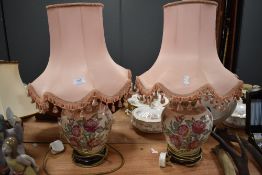 Two large ceramic table lamps with pink shades having pink rose design.