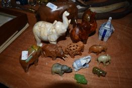 A collection of elephant ornaments, different styles and sizes including wood and ceramic examples.