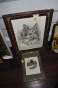 A framed Alsatian print and small signed painting of a cottage in woodland.