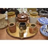 A mixed lot of vintage earthenware including jars,platter with drainage spout,lidded bowl and more.