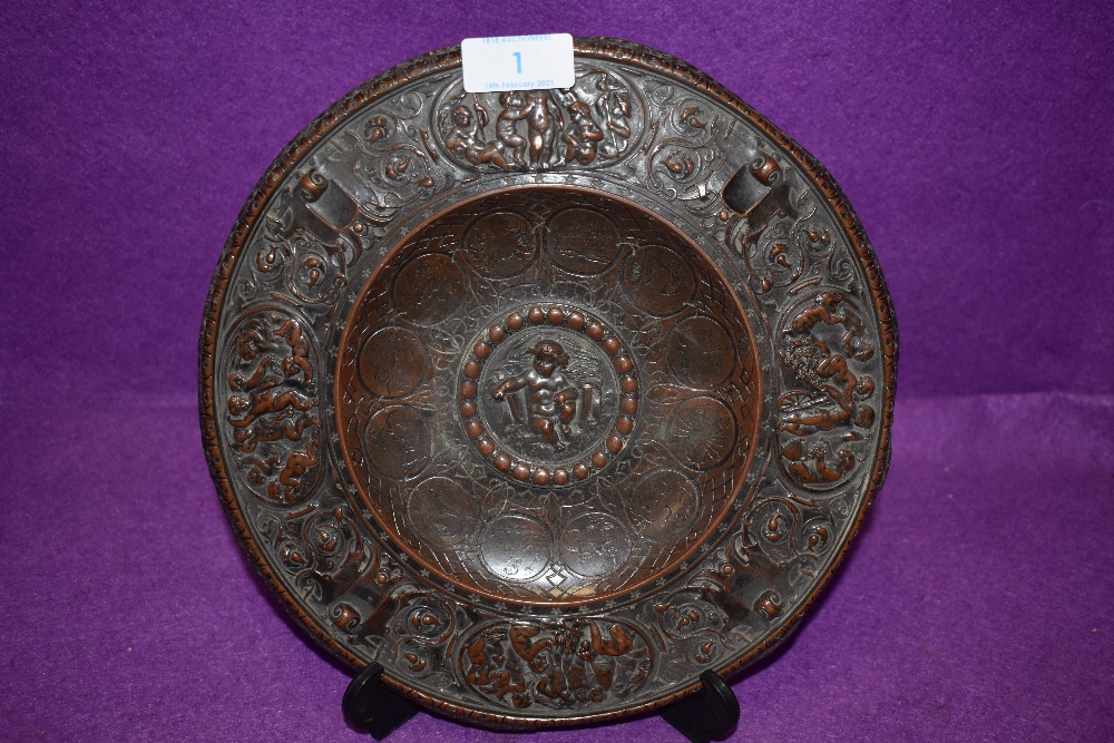 An antique bronze footed tazza or plaque decorated with cherubs and signs of the zodiac bearing