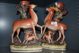 A pair of antique spill vases both in the form of tree stumps,one having deer and fawn the other