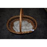 A wicker basket and a crotchet table runner.