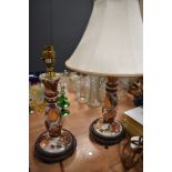 A pair of ceramic table lamps with shades having fruit design and gilt detailing.