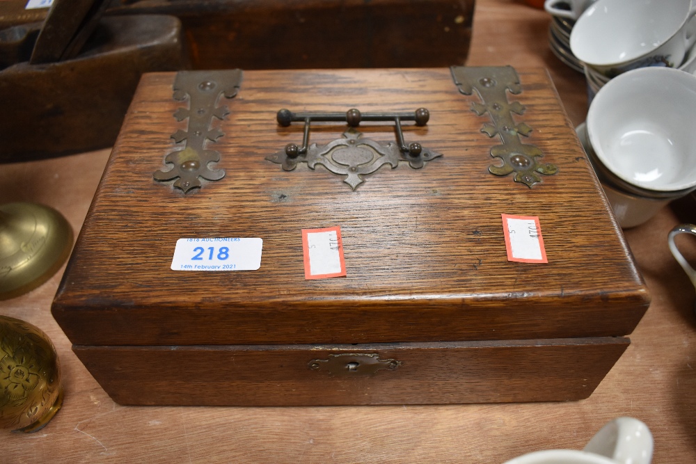A small oak box with ornate handles and hinges and a selection of button hooks and similar one