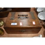 A small oak box with ornate handles and hinges and a selection of button hooks and similar one