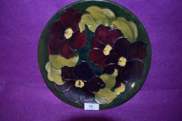 A Moorcroft plate having green ground with hibiscus like floral tube lined pattern,marked