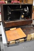 An antique hand cranked Singer sewing machine in case ED191097