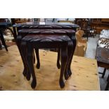 A reproduction mahogany effect nest of three tables