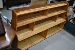 A pine and chipboard back low bookcase, width approx. 170cm