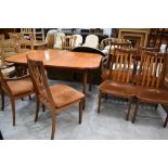 A vintage teak extending dining table and six (four plus two) rail back dining chairsm labelled G