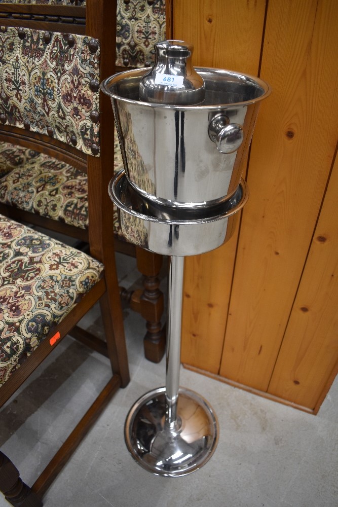 A chrome ice bucket on stand and cocktail shaker