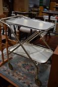 A vintage fold away tea or cake trolley in polished metal