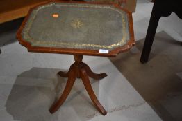 A reproduction tilt top wine table