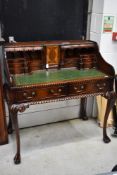 An elaborate reproduction hardwood desk or library table having extensive classical decoration