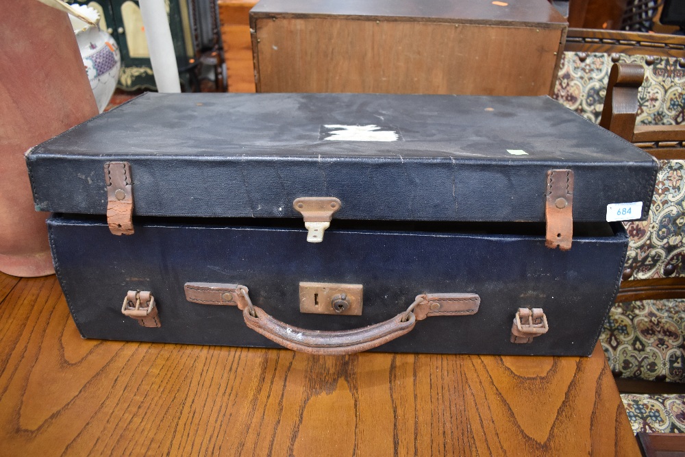 A vintage travel case having leather handle and straps, bearing part label