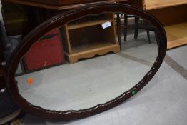 An oval carved and scalloped frame wall mirror