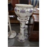 A late 19th/early 20th Century ceramic jardiniere and stand, unfortunately cracked throughout