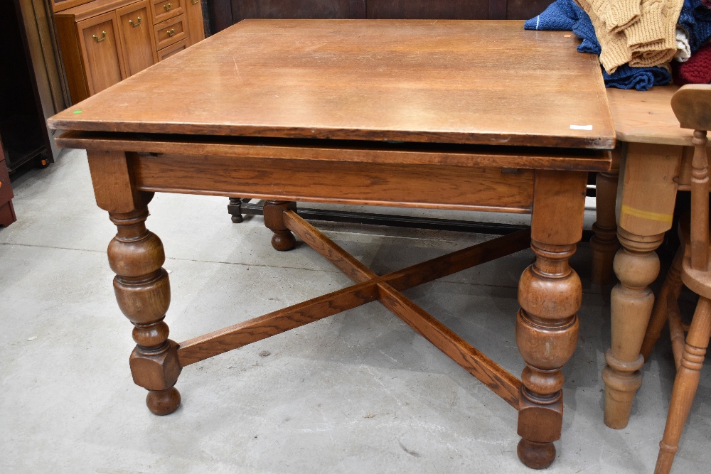 An early to mid 20th Century oak drawer leaf table on cross stretcher and bulbous column legs,