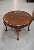 A circular low table having cabriole legs and mahogany frame