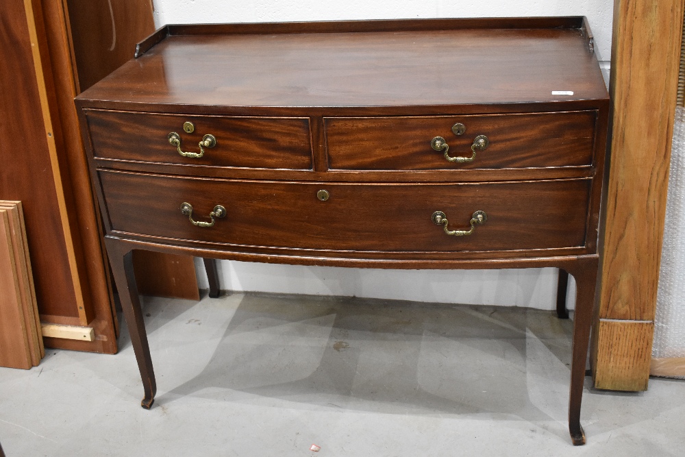 An early 20th Century mahogany dressing chest of two over one long draw, having bow front and