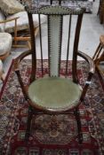 An oak stained smokers or similar arm chair having spindle back and studded upholstery