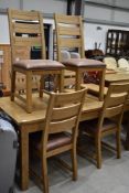 A modern light oak extending dining table and set of six matching chairs by Willis and Gambier