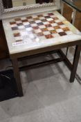 A heavy brass effect framed stone cut and inlayed chess or games board also ideal side table